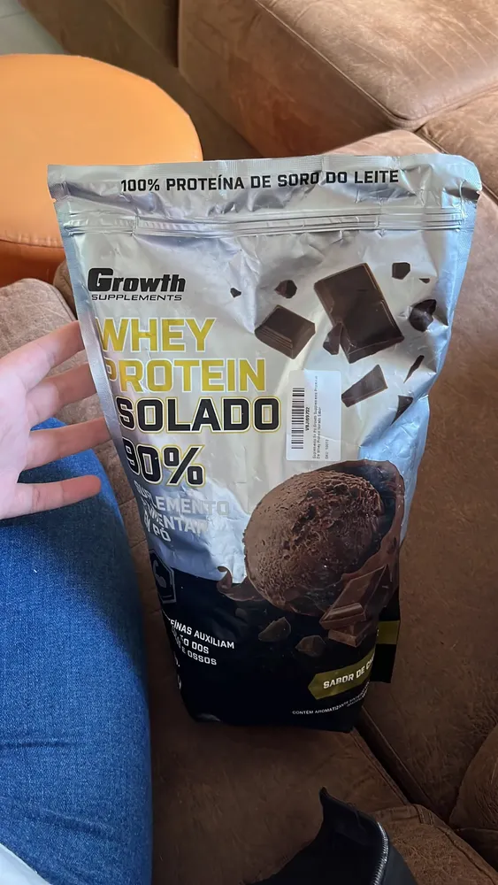 Cliente mostrando o pote de Whey Isolado Growth 1kg sabor chocolate